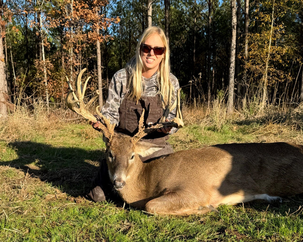Person with a large deer in a forest setting