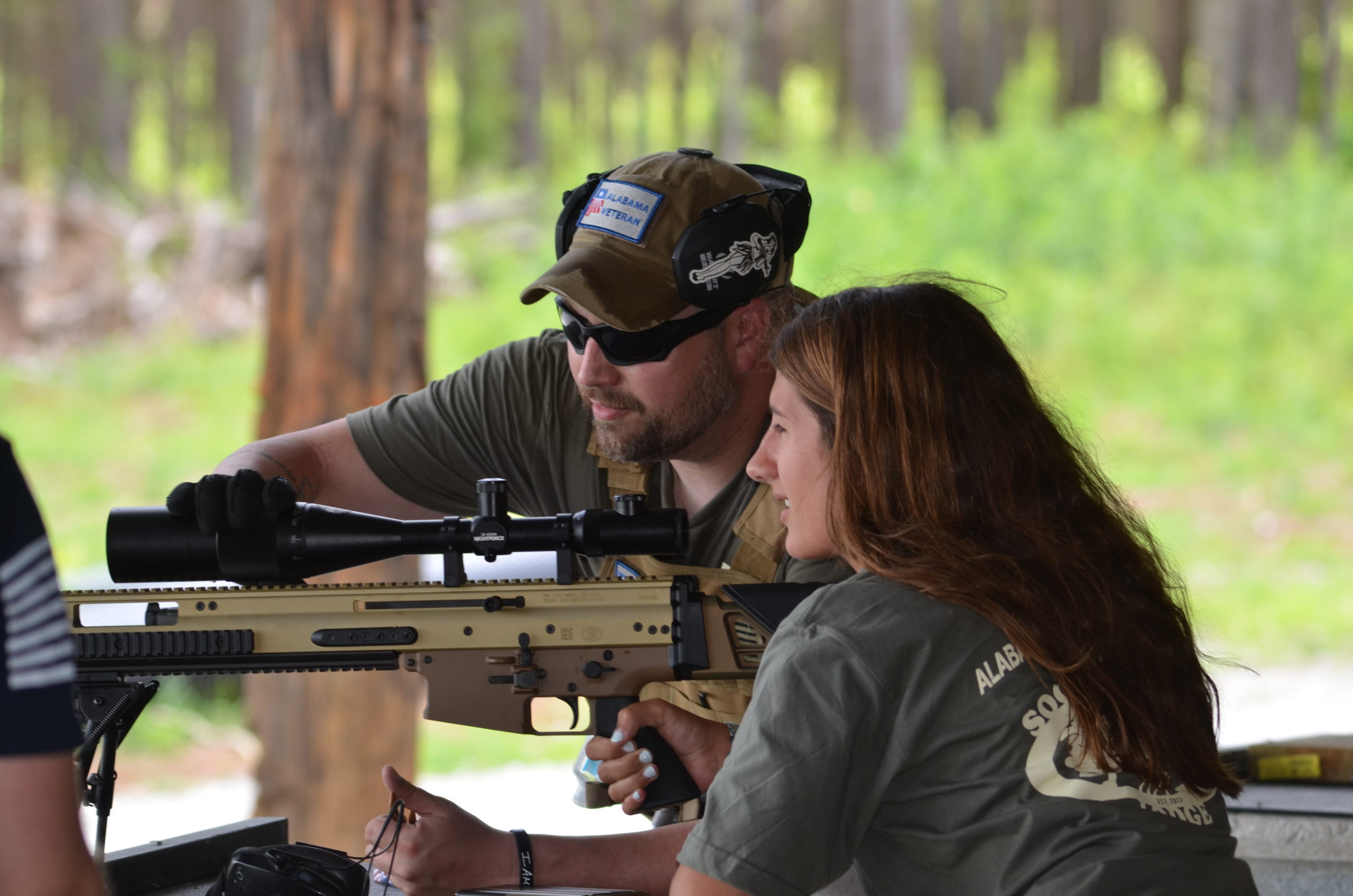 woman at an outdoor gun range being taught by a licensed instructor